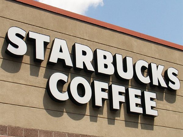 Front-lit channel letters spelling Starbucks Coffee on a building